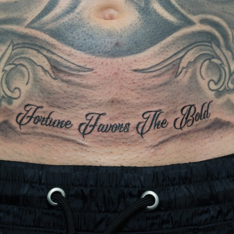 text filler tattoo, fortune favors the bold, tattoo on the front waist area - endless heights tattoo by artist dj donald voelker